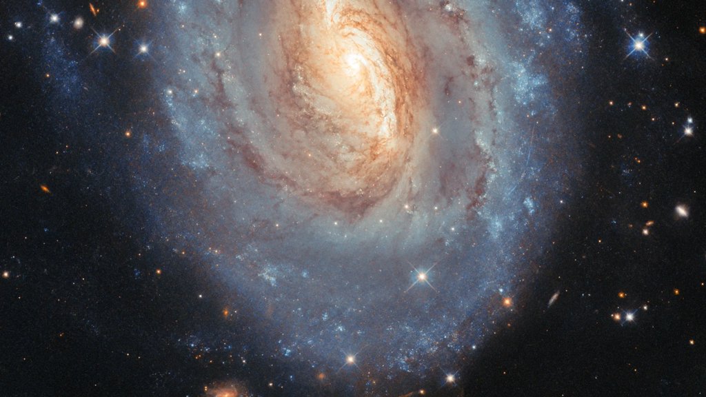 Hubble captures a galaxy that glows in blue and gold | ScienceDaily